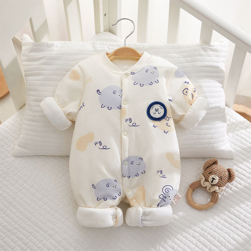 Baby onesie with animal patterns on a hanger in a crib