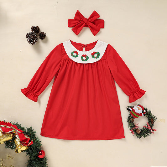 Red dress with Christmas-themed collar and accessories on a beige background