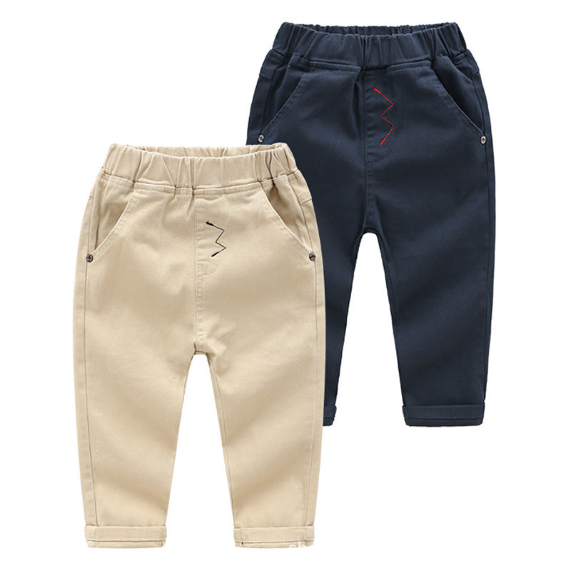 Two pairs of children's pants, one beige and one navy, on a white background.